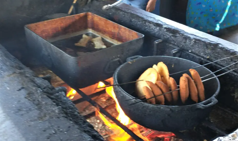 2 pans on a fire stove Frying up the food at the kiosks in Pinones