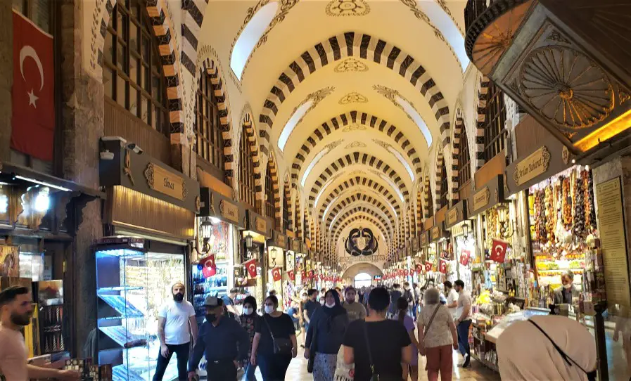 lots of people in a shopping bazaar in Istanbul with colorful shops on each side