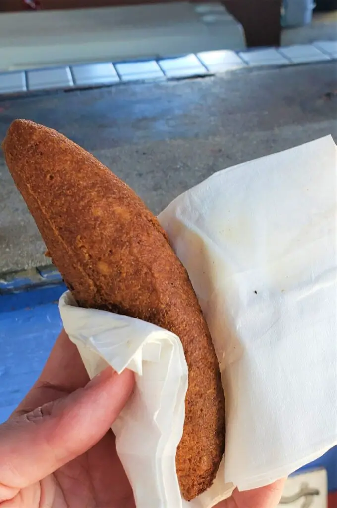 long fried food in a napkin alcapurrias - traditional Puerto Rico Food