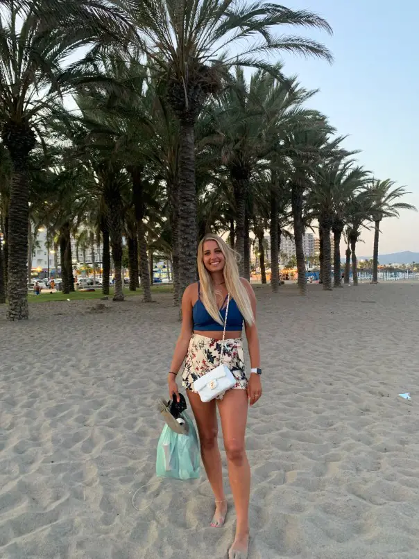 standing on the sand in front of palm trees on Banjondilla - one of the best beaches near Malaga Spain