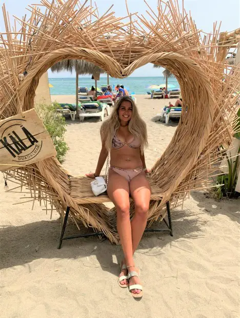 girl sitting in a heart prop at Guadalmar - Malaga Beach