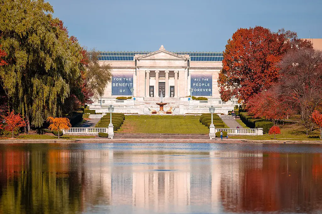 fancy building in front of a calm pond