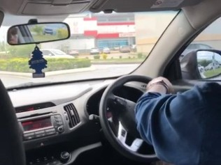 steering wheel on the right side of the car as a man drives in Trinidad and Tobago