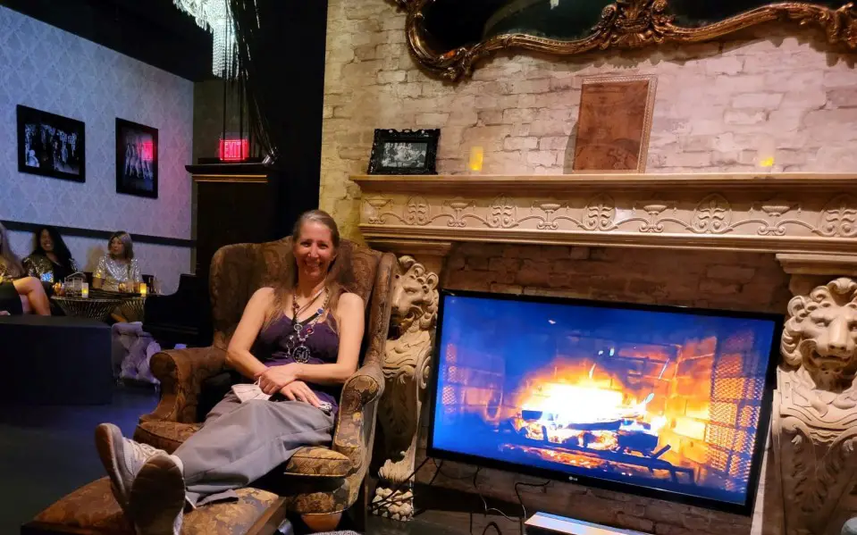 lady in a comfy chair with feet up in front of a digital fireplace at 1923 Prohibition Bar - Speakeasy in Las Vegas