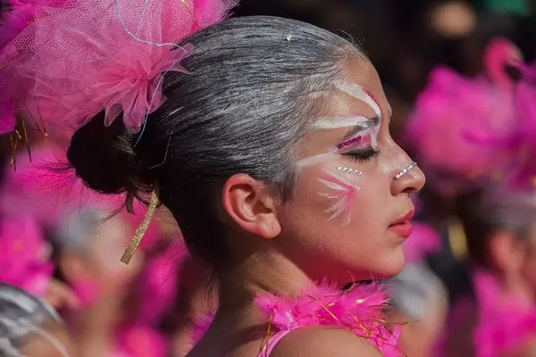 closeup of a lady in a pink outfit with her hair up at Carnival in Trinidad