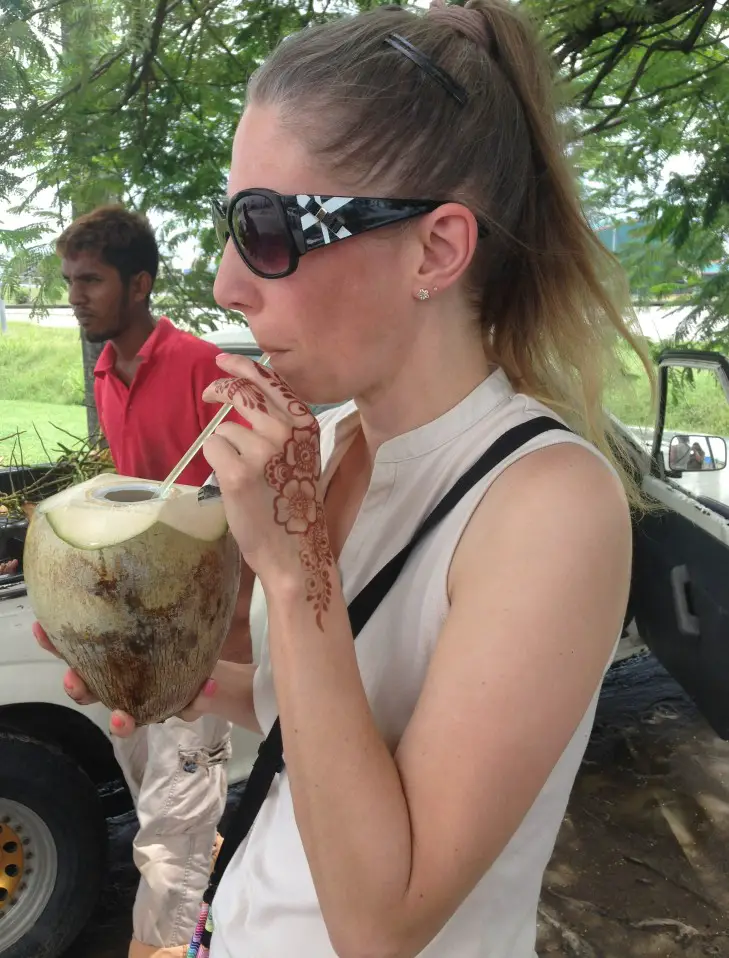 Things to do in Trinidad include drinking a coconut from a straw from a roadside vendo