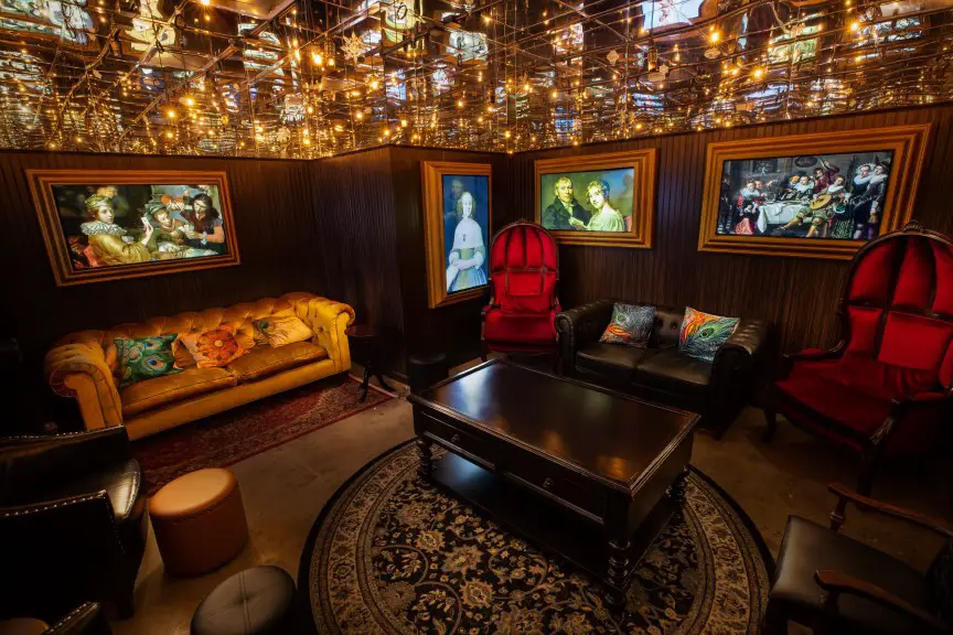 room with golden ceiling, leather furniture, and lots of portrains on the wall