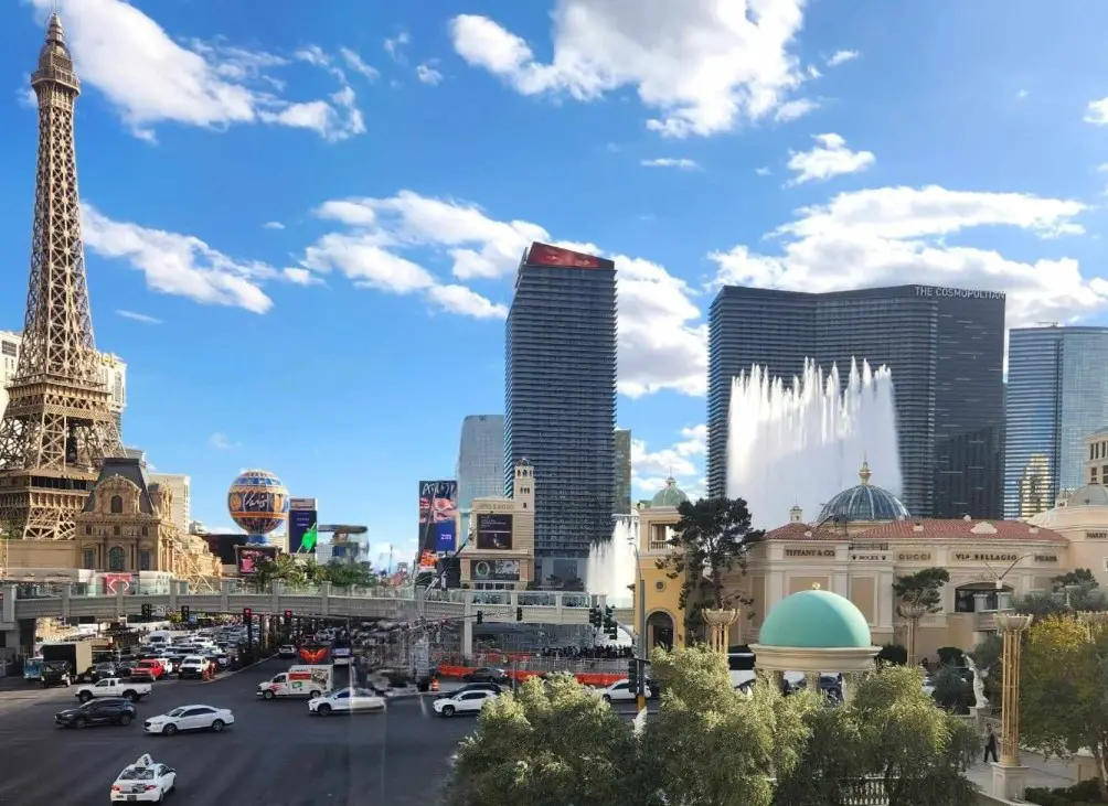 las vegas strip view of street from bridge with buildings and fountain.