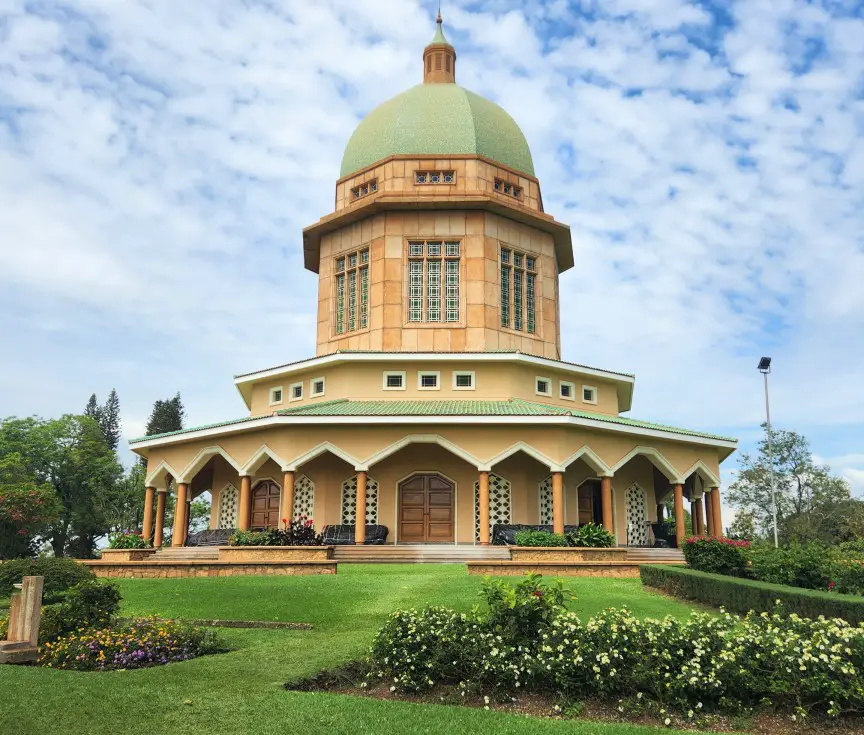 large dome building in front of green grass - temple in kampala
