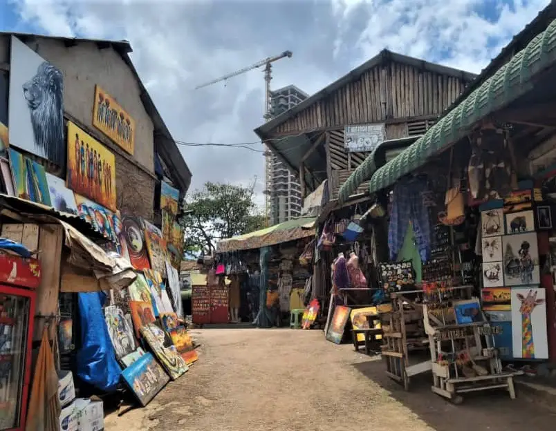 colorful crafts and paintings line the Kampala street at the craft village on our one day tour in Kampala