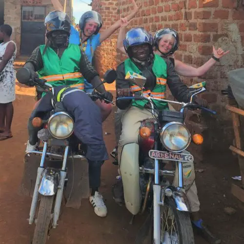 2 ladies on the back of a boda boda motorbike for a city tour in kampala