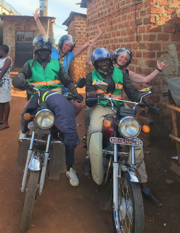 2 ladies on the back of a boda boda motorbike for a city tour in kampala