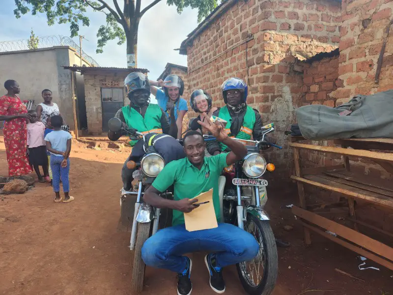 people gathered around 2 boda boda motorbikes during a kampala city tour in uganda