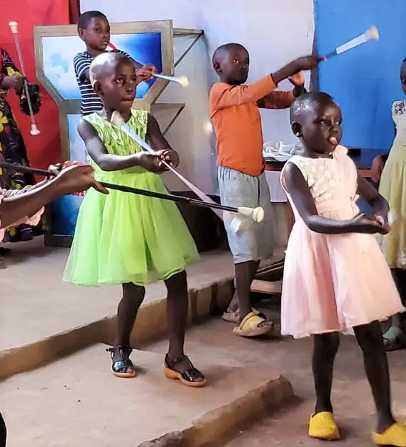 girls in dresses twirling baton on the step in the club banda orphanage