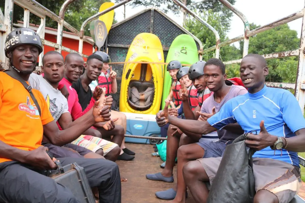 lots of people sitting on benches in the trailer on the way to start the white water rafting trip in Uganda