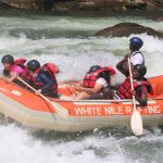 group in an orange rafting boat on the white water rapids