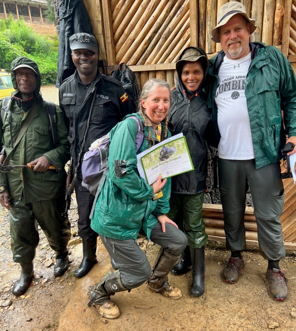 people standing in the mud with a gorilla trekking certificate in Uganda