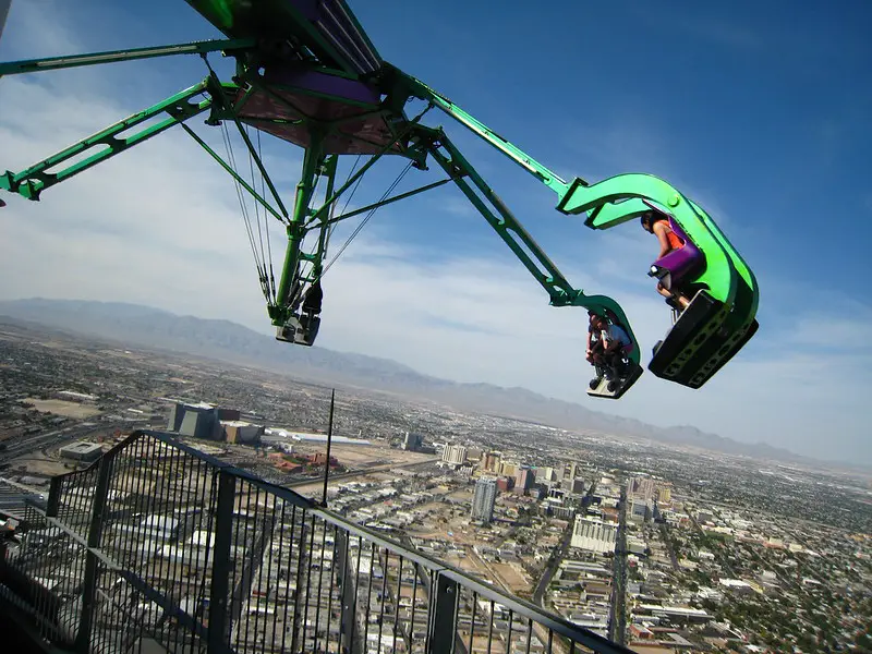 people in a green ride dangling way up high on Insanity Thrill Ride in Las Vegas