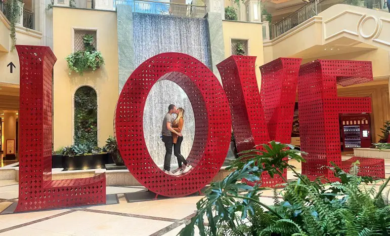 couple kissingin the O of LOVE letters in a lobby in Las Vegas hotel
