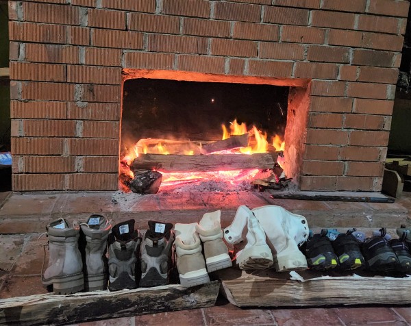 several pair of freshly cleaned hiking boots in front of the fire after the gorilla trek in Uganda