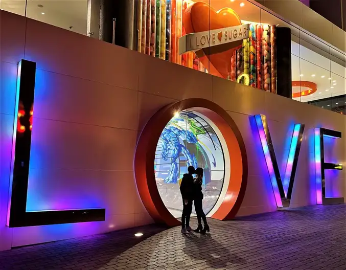 shadow of couple kissing in neon LOVE letters in Las Vegas