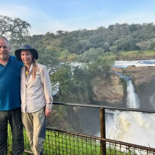 couple standing in front of a waterfall in Uganda