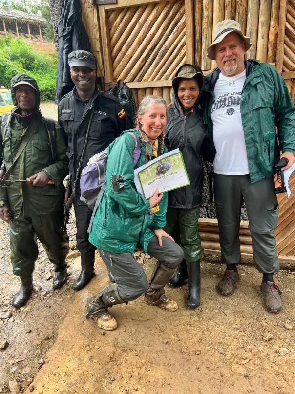 wet and muddy people with certificates after a gorilla trek in uganda