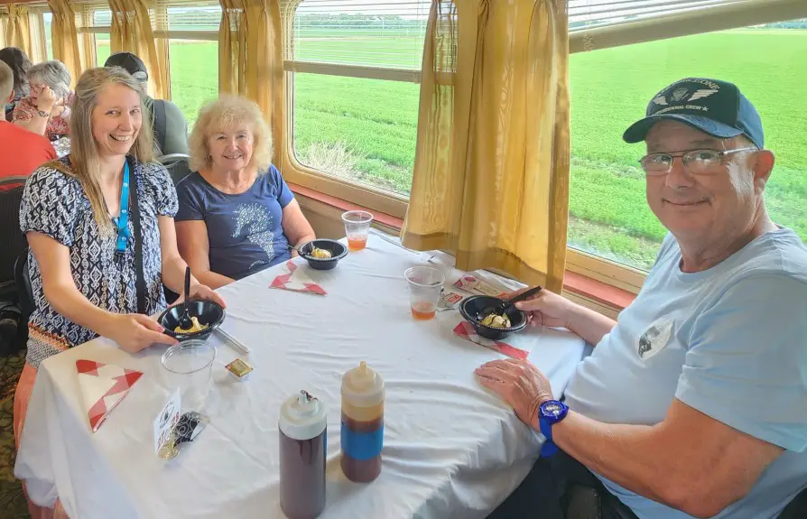 3 people at a dinner table on board a train in Abilene