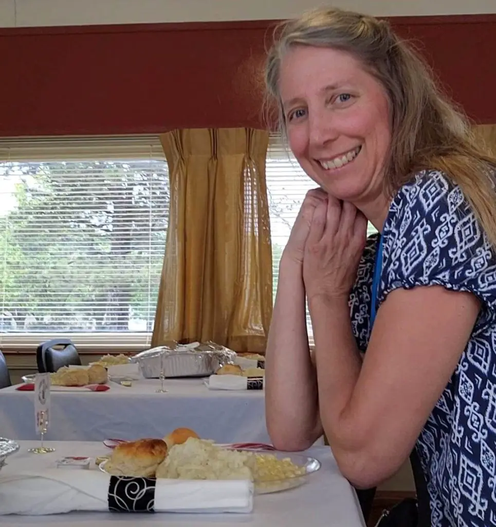 lady smiling at a table with side dishes on a dinner train in Abilene kansas