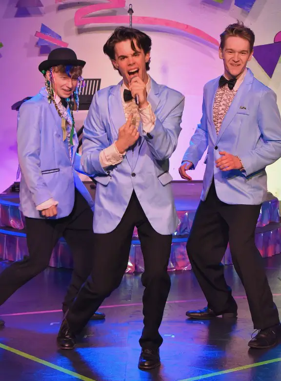 three guys in blue tuxedos singing in microphones at Great Plains Theatre in Abilene Kansas