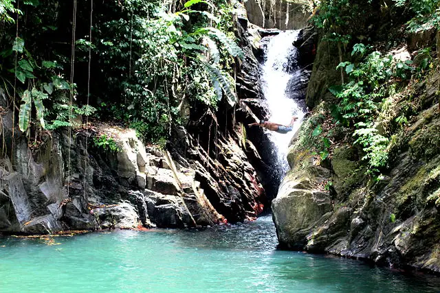 man jumping into waterfall in Trinidad and Tobago