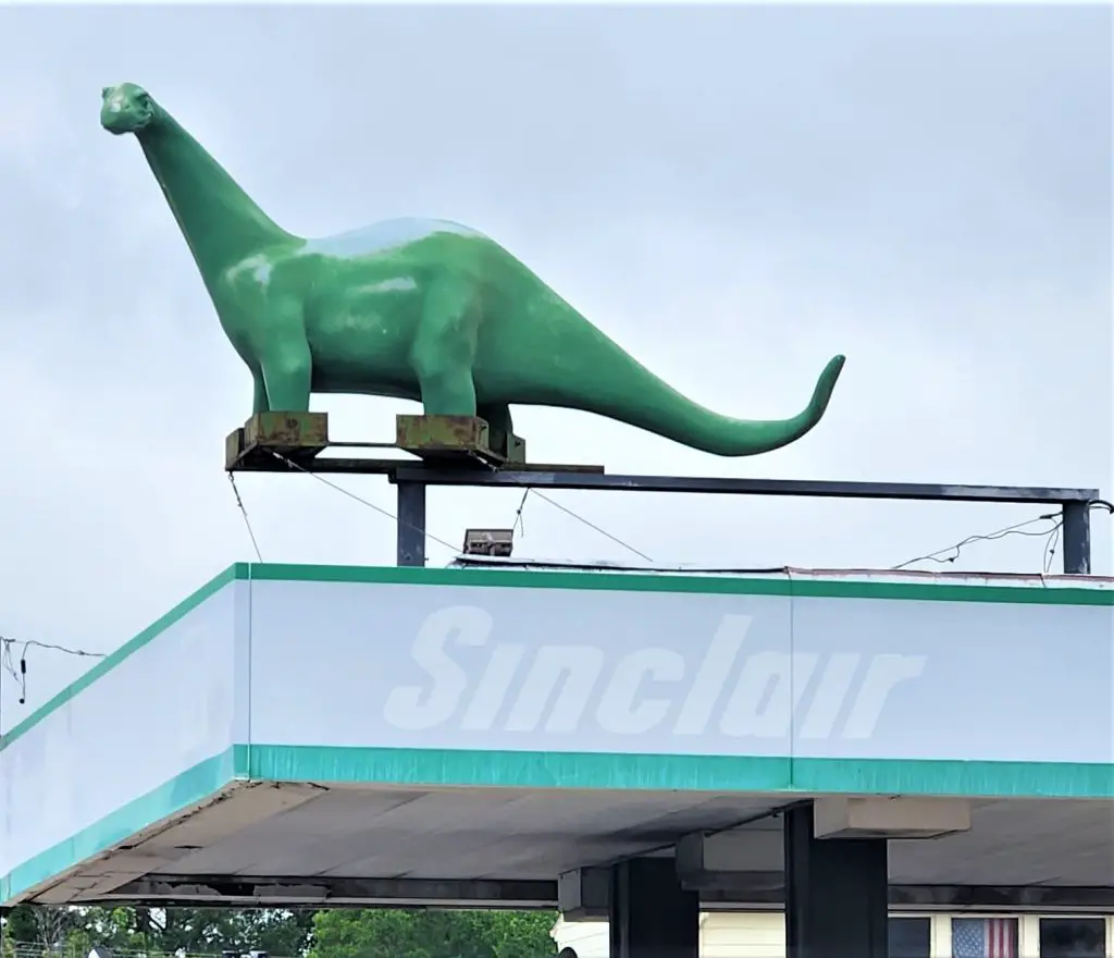 green sinclair dinosaur on the top of a roof of a repair shop in Abilene Kansas