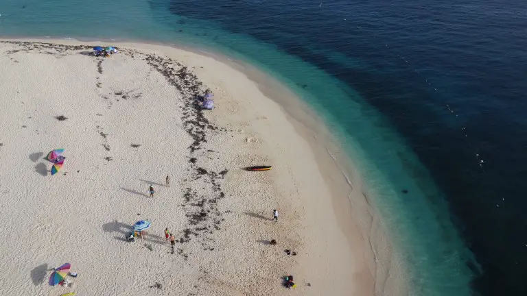 aerial view of a sandy beach near the blue water