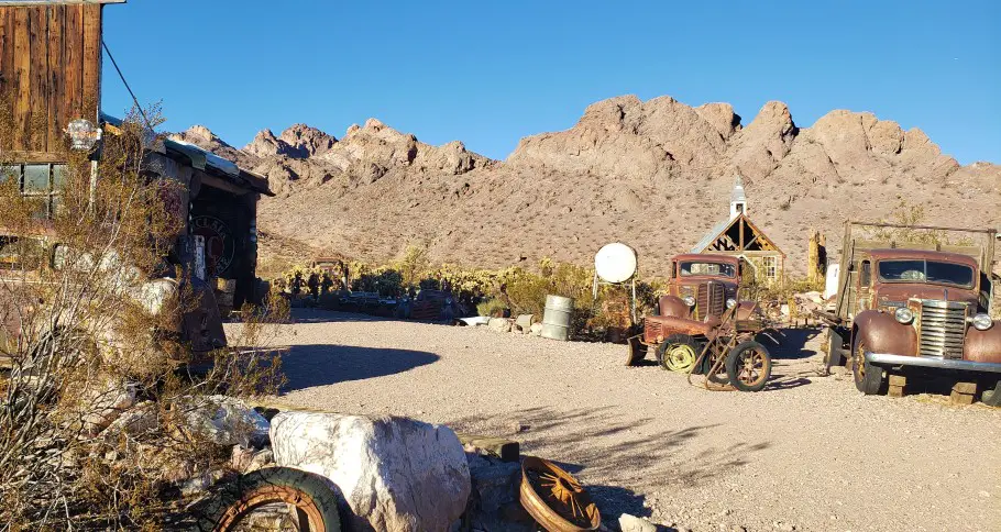 mountains in the backdrop of old cars and buildings in a ghost town in Las Vegas