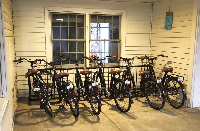 bikes on a bike rack in front of an old white building in Shipshewana at the Farmstead Inn