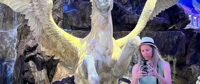 lady taking a selfie in front of a flying horse fountain in Las Vegas