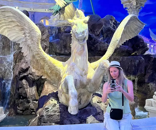 lady taking a selfie in front of a flying horse fountain in Las Vegas