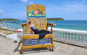 lady in hat and a bathing suit sitting in a chair in front of a water view in Vieques Puerto Rico