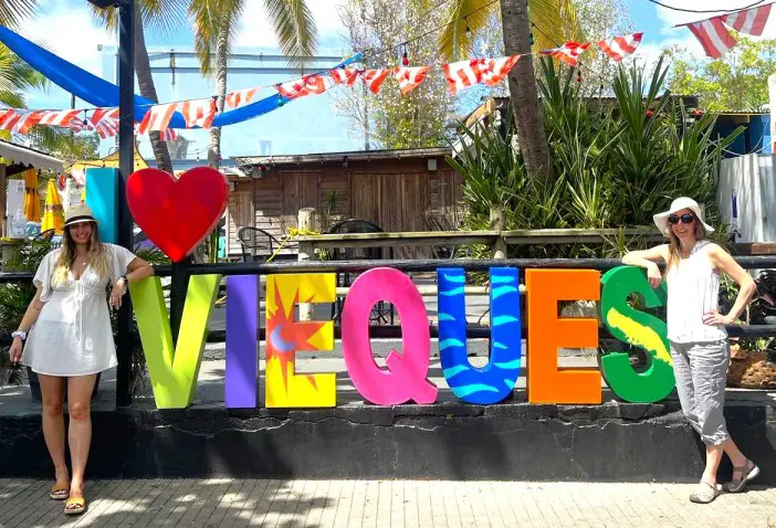 2 ladies standing in front of an I Heart Vieques sign beginning their Vieques Itinerary in Puerto Rico