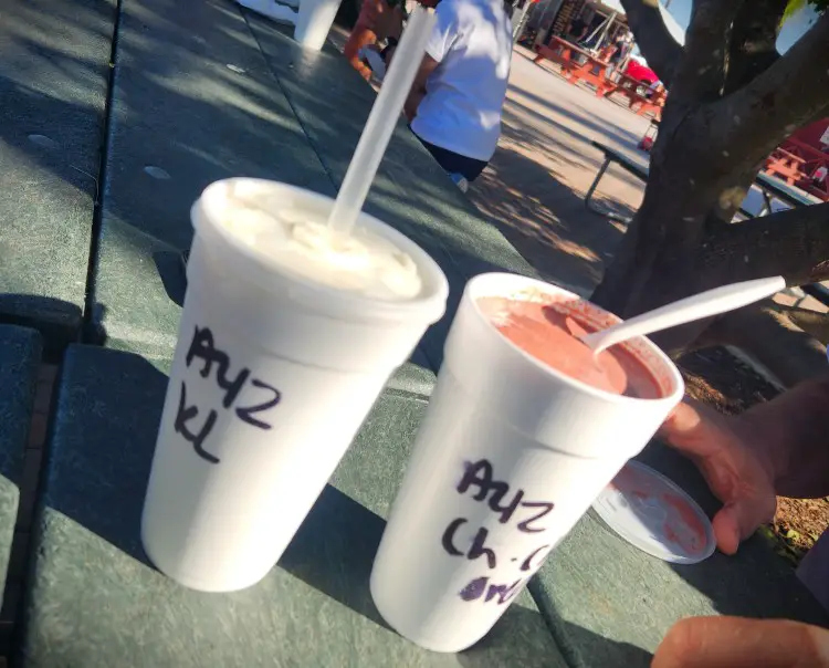 milkshakes in white styrofoam cups with straws sticking out of them