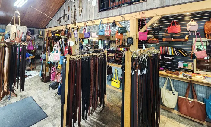 store with racks of leather belts and purses