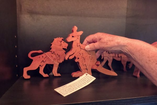 holding on to a kangaroo wooden puzzle with a lion puzzle in the background at Teaberry in Amish country in Indiana