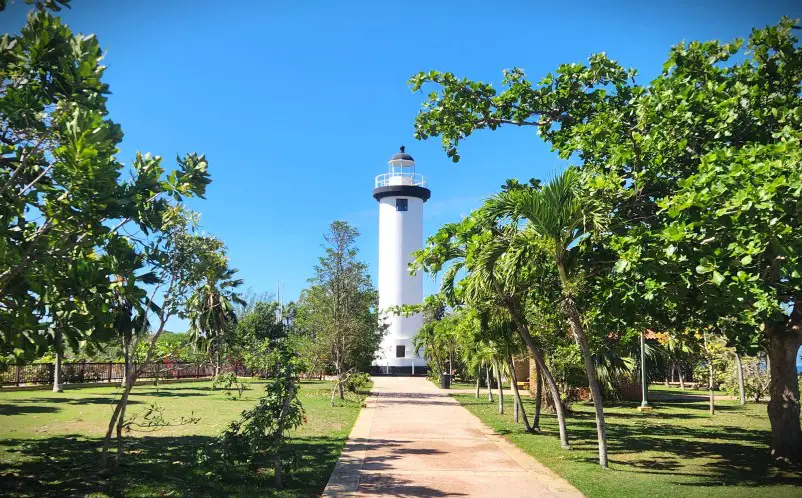 white lighthouse tower at the end of a long walkway