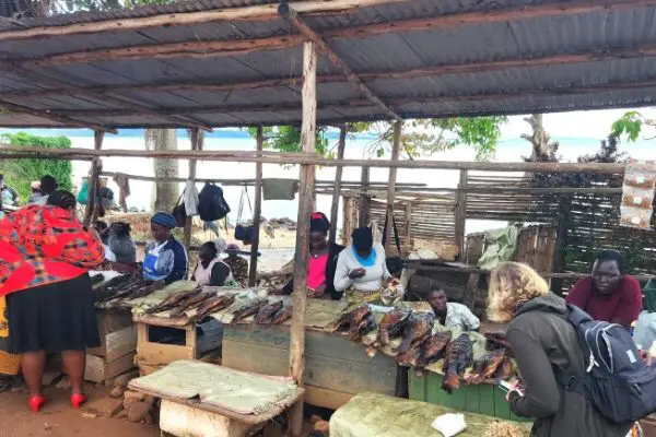 people selling fish under a metal awning