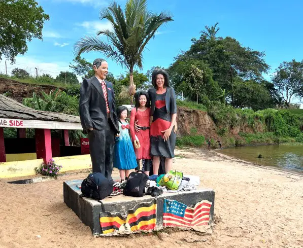 4 statues on a pedestal on the sandy beach overlooking the water