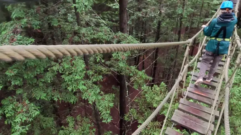 wooden bridge at Altitude in New Zealand with lady crossing on a carabiner
