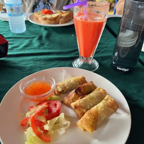 plate of appetizers with a pink fruit smoothie in the background