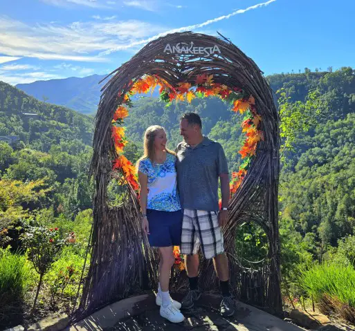 couple looking at each other under an Anakeesta sign in the mountains