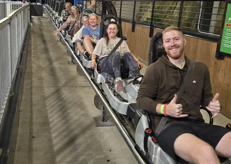 many people sitting in a roller coaster seat and seat belted in