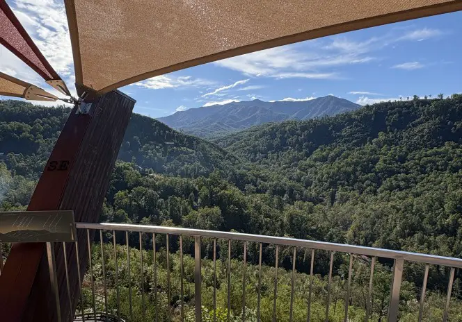 canopy overhead and railing in front with green trees of the Smoky Mountains in the background